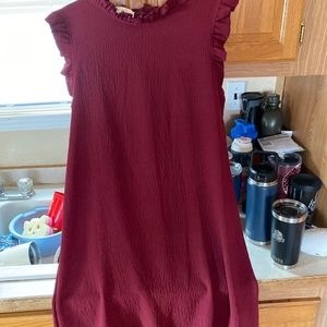 A boutique style dress maroon in color goes just passed the knees